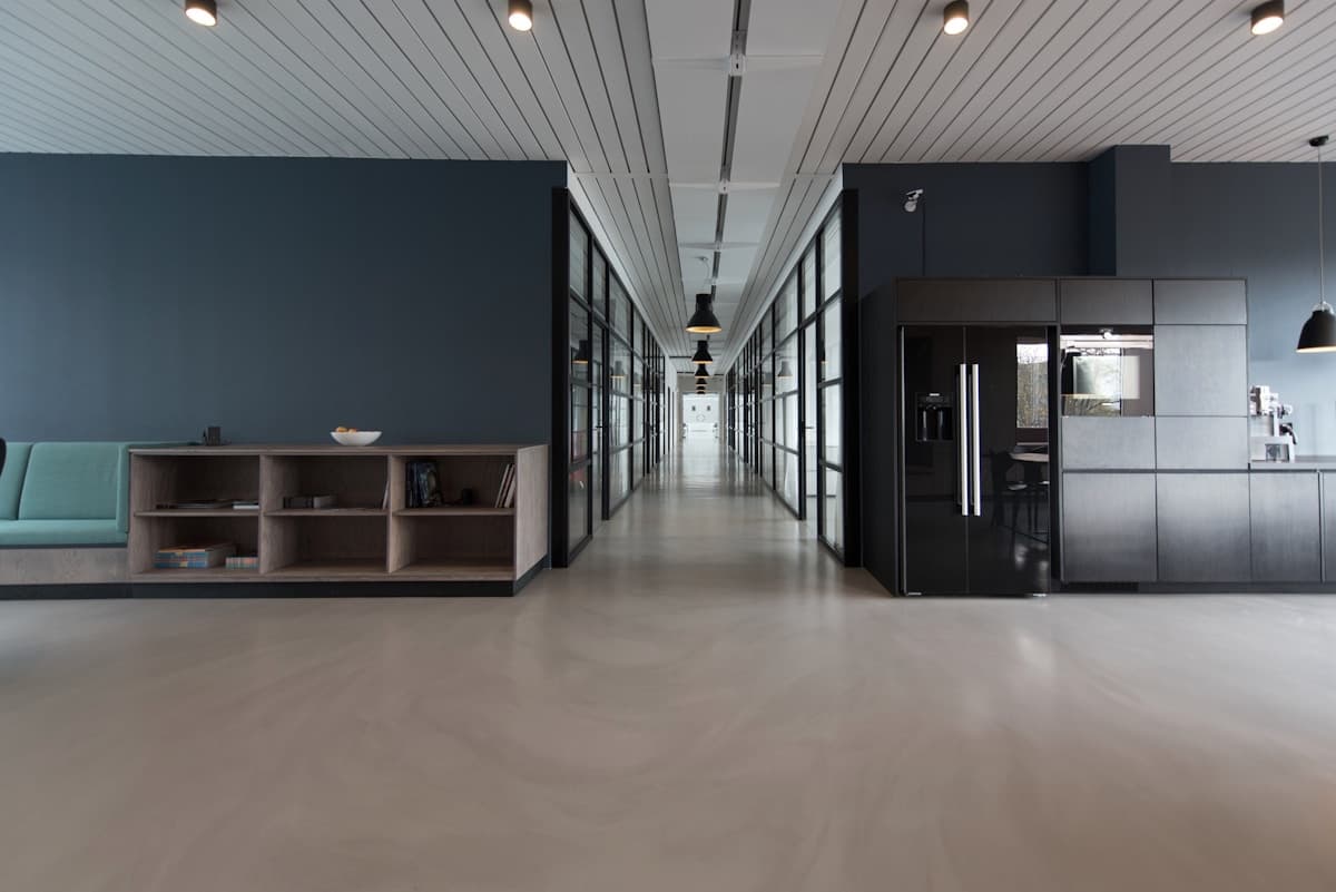 Bright studio workspace with desks, models, and natural light from tall windows